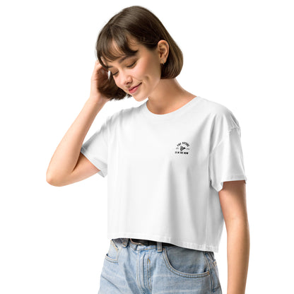 Woman wearing a white t-shirt with a black graphic design on a white background. Sleek streetwear crop top perfect for workouts or everyday mindset wear.